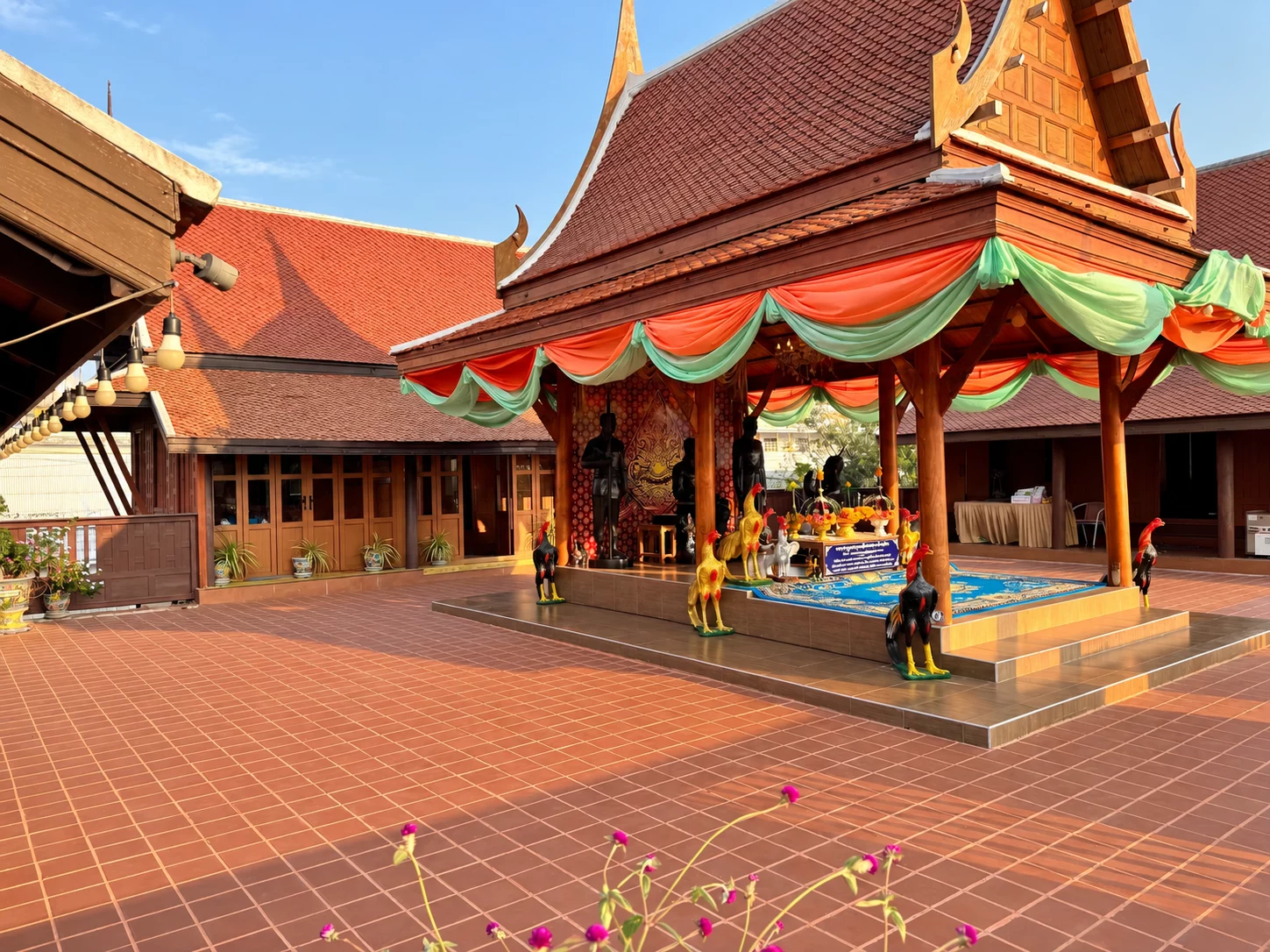 สีพื้นแดงน้ำตาลเชื่อมศาลกลางลานกับอาคารไม้โดยรอบ
