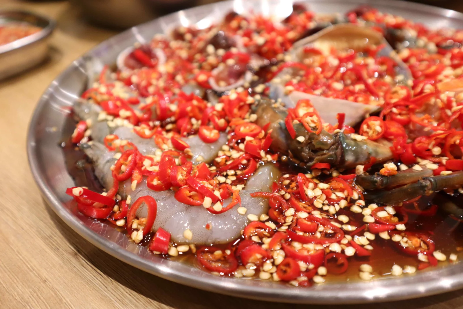 ปูดองในน้ำซีอิ๊ว พร้อมพริก กระเทียม และงา จากภาพอาหารของร้าน